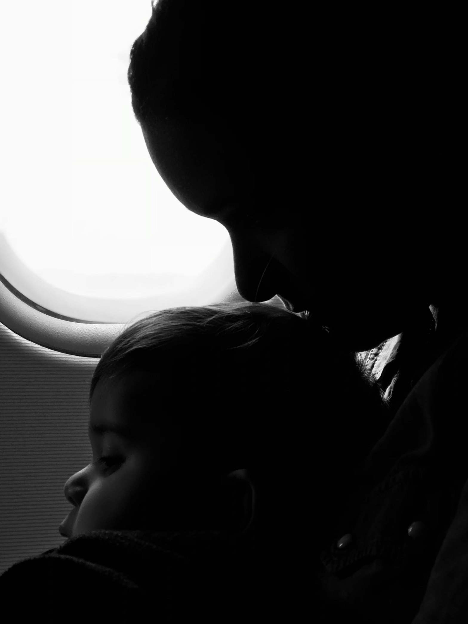 A mother with her kid and shadow of aeroplane seat