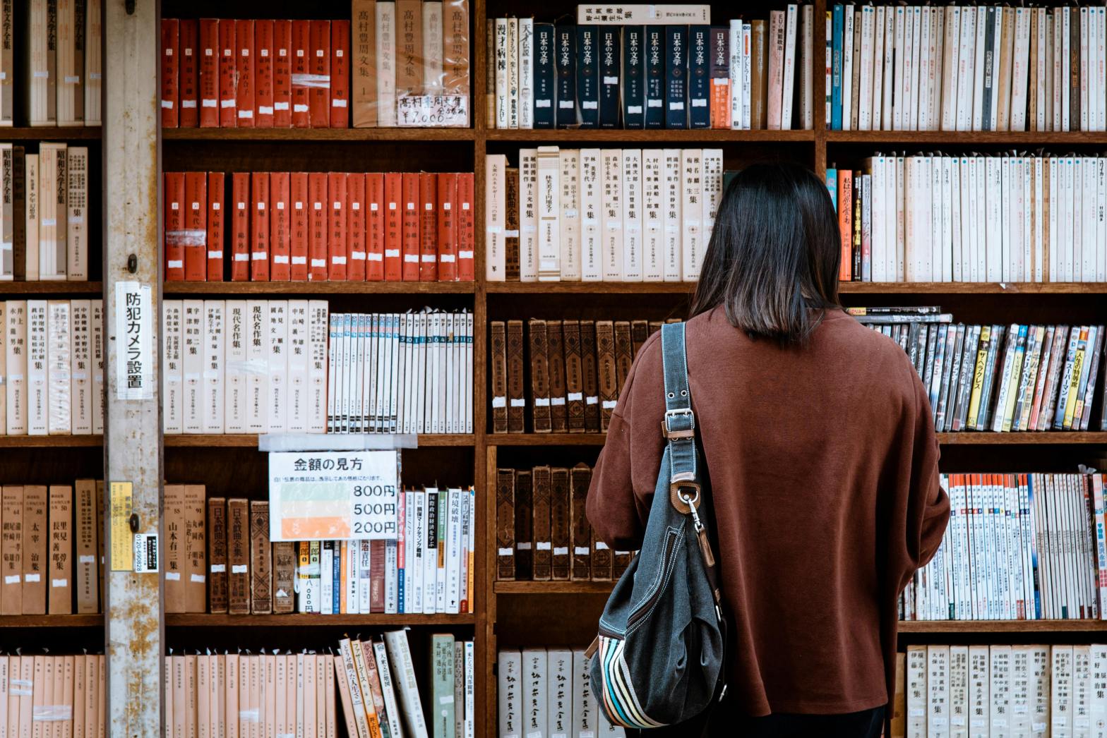 A girl standing in Library with books.